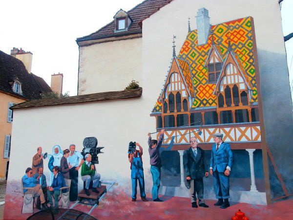 А вот так благодарные французы увековечили память не только любимого актера, но и любимого фильма. На фреске на торце одного из домов городка Бон в Бургундии запечатлен момент съемок фильма "Большая прогулка". Некоторые сцены комедии снимались в Боне в 19